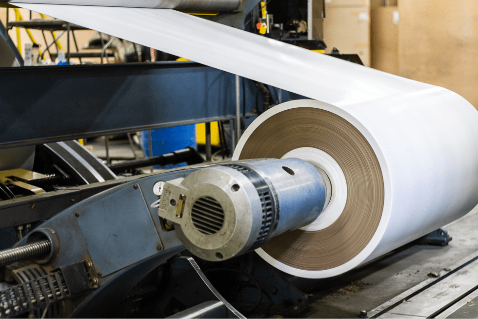 Polyethylene film web running off the extrusion coating line over a kraft core